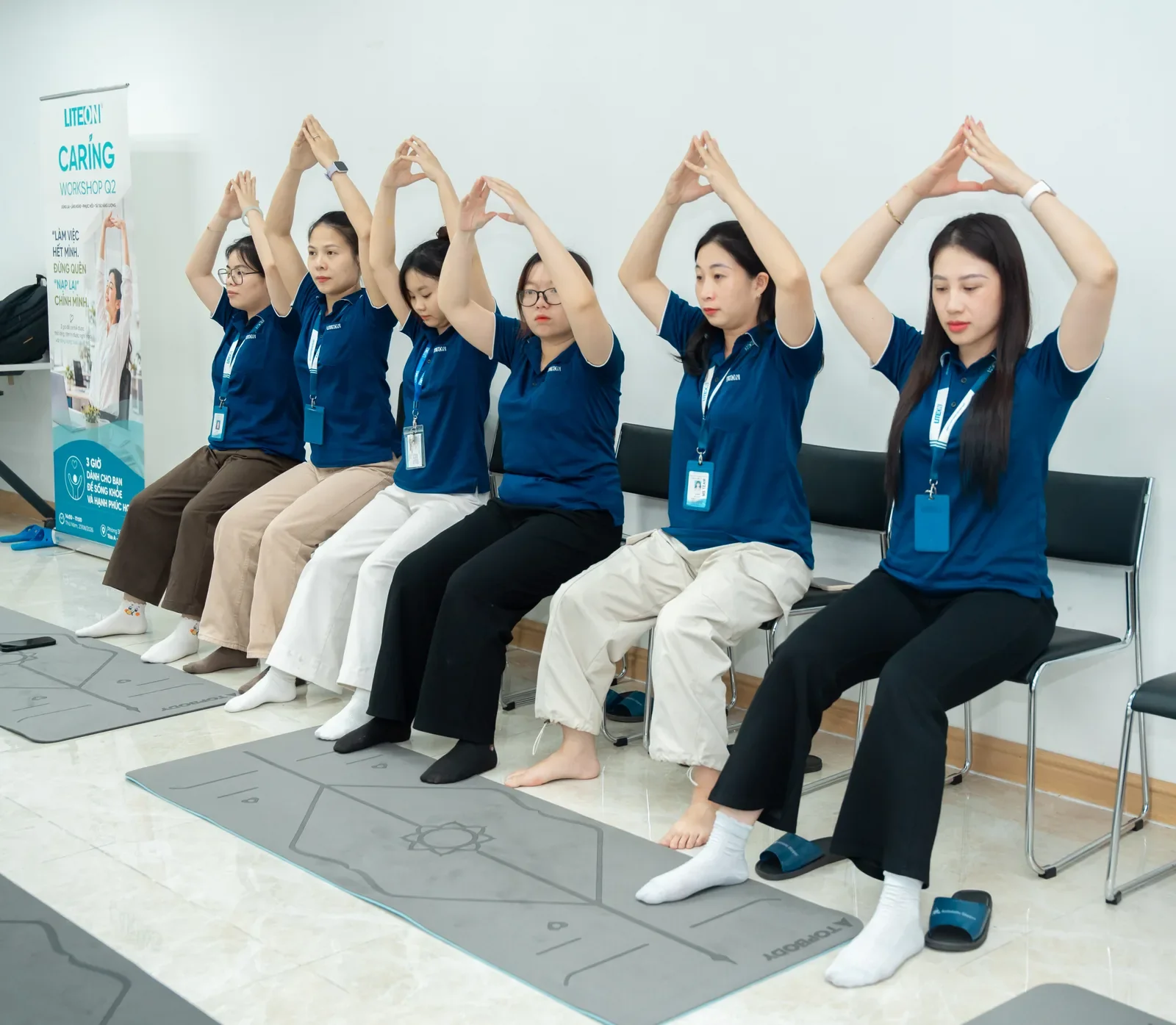 Nhóm nhân viên thực hành động tác khởi động tại Workshop Yoga