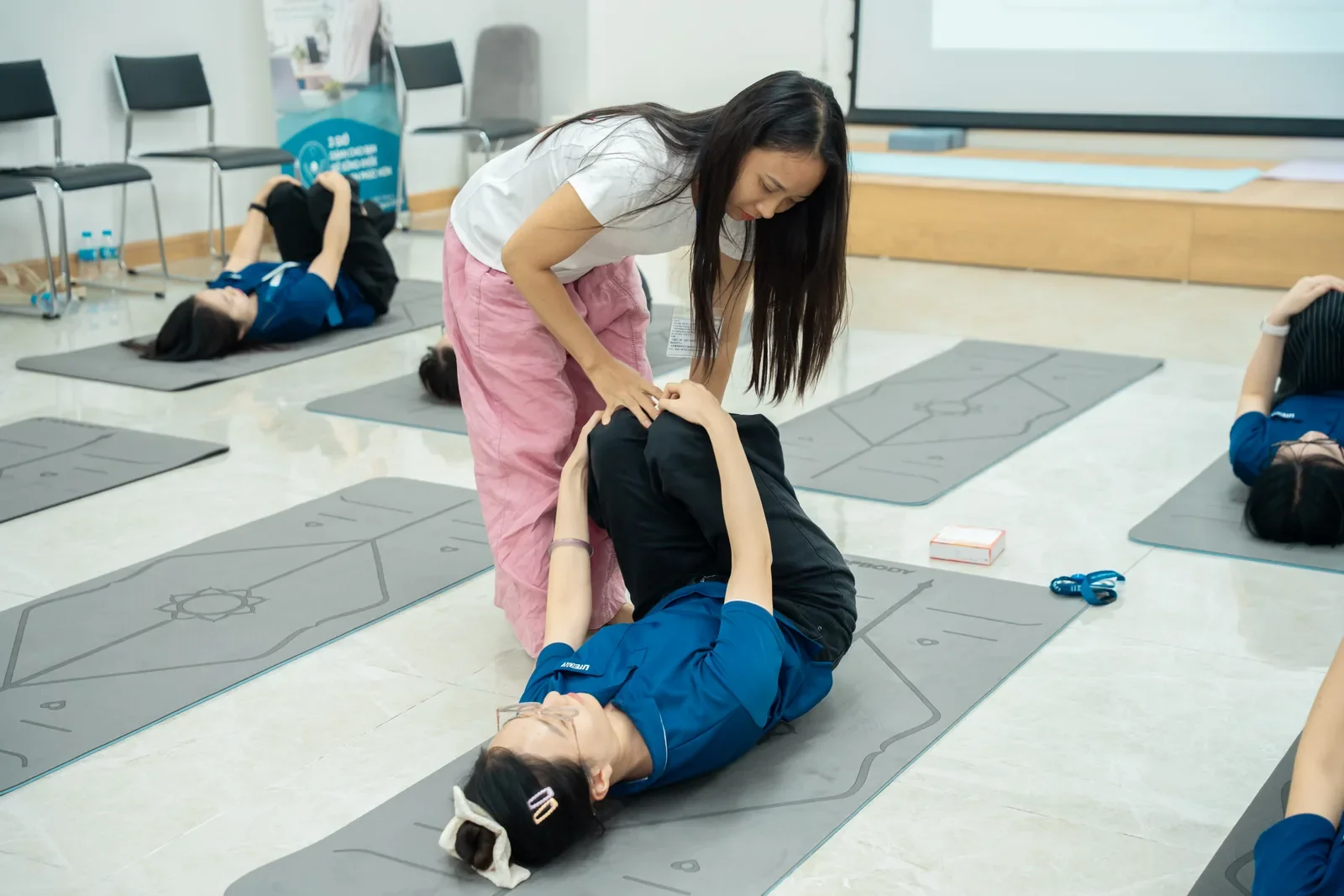 Huấn luyện viên hỗ trợ người tham gia điều chỉnh tư thế